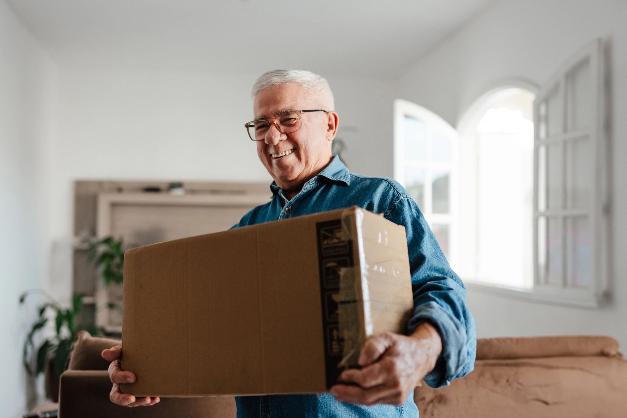 Older adults carrying boxes while preparing to simplify their home