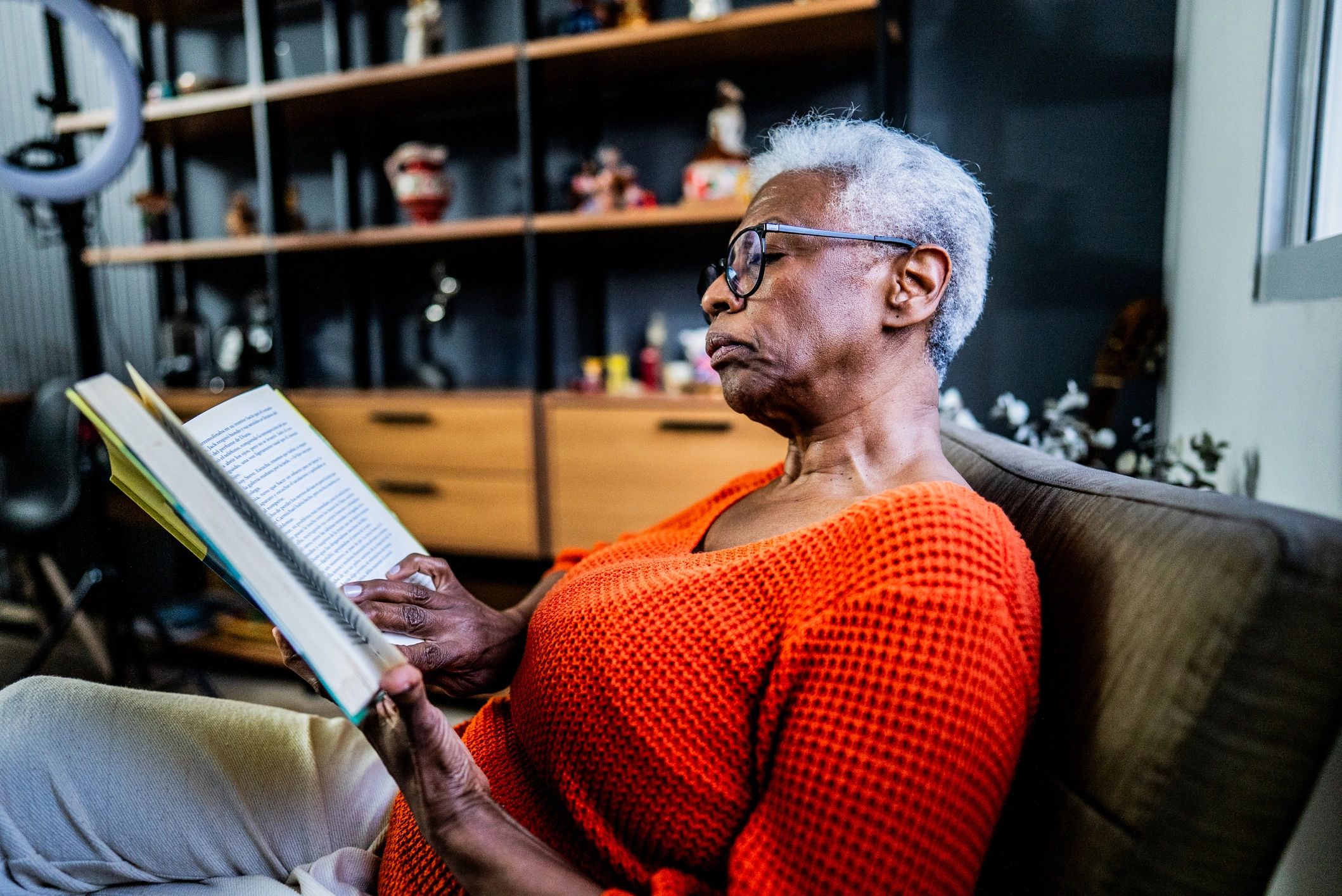 Senior woman reading a book at home
