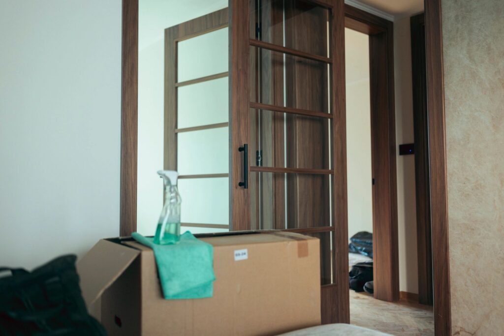 Cardboard box with cleaning supplies in new apartment